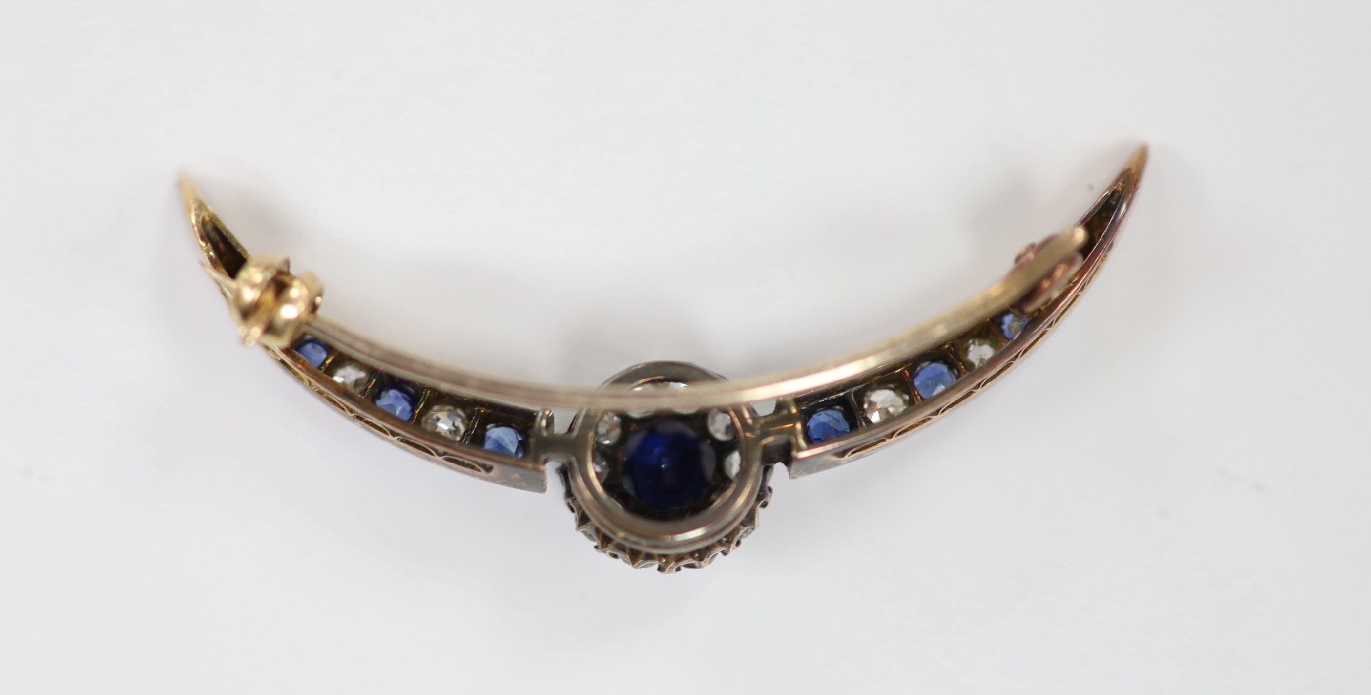 A Victorian yellow metal, sapphire and diamond cluster set crescent brooch, 42mm, gross weight 3.9 grams.